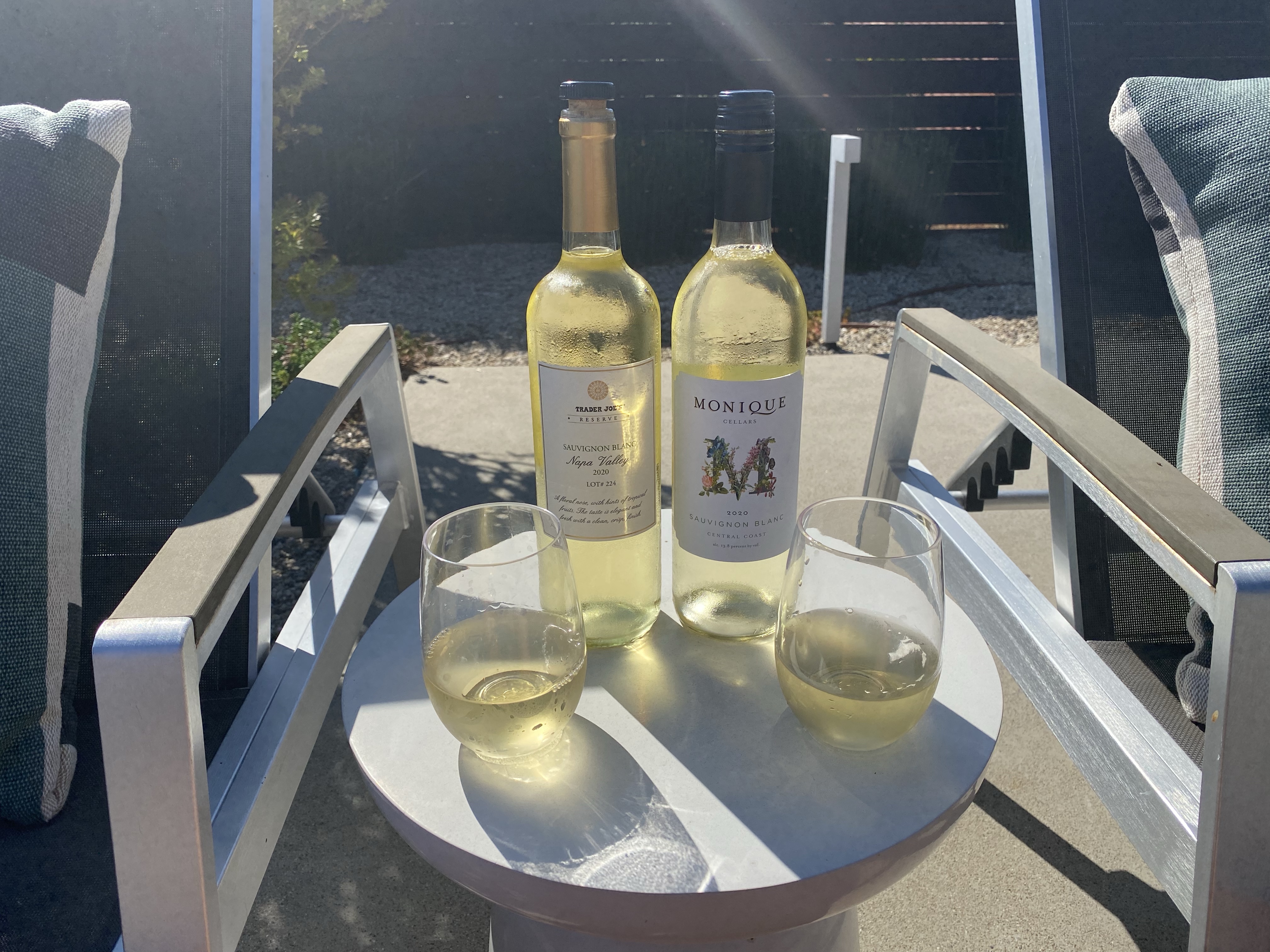 Bottles and glasses of Trader Joe's Reserve Napa 2020 Sauvignon Blanc (L) and Monique Cellars 2020 Sauvignon Blanc (R)