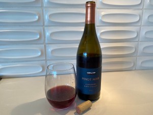 Glass and bottle of the 2020 Kirkland Signature Pinot Noir, Carneros, Napa Valley, California.